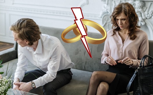 Ein Foto eines Paars, welches weit auseinander auf einem Sofa sitzt. Beide schauen unglücklich. Auf dem Foto ist ein Icon von zwei Eheringen eingefügt, die von einem Blitz getrennt werden.