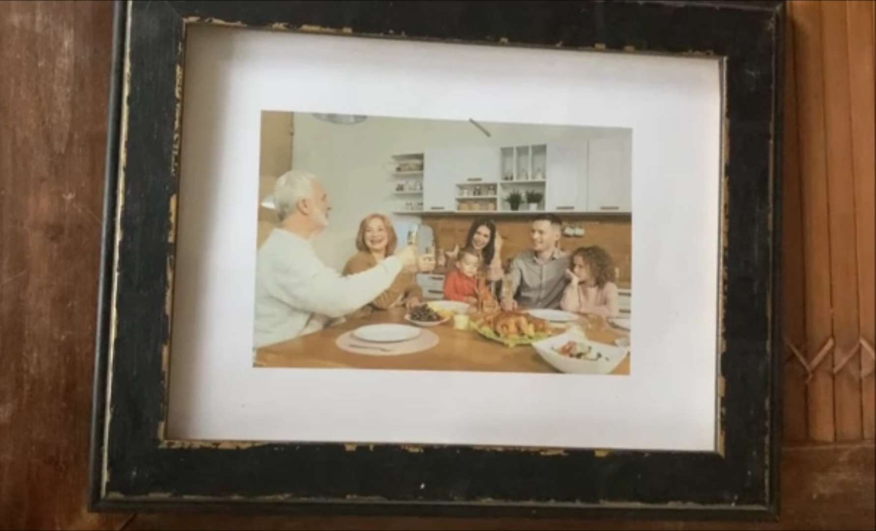 Ein Foto einer Familie am Essenstisch. Zu sehen sind zwei Großeltern, zwei Eltern und zwei Kinder.